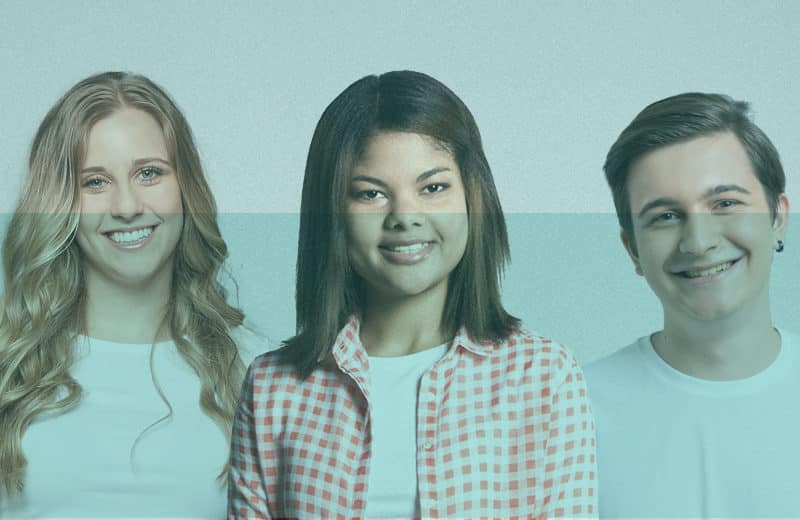 Tres jóvenes candidatos de Fundación Adecco sonríen. Visten con camiseta blanca y están muy contentos.