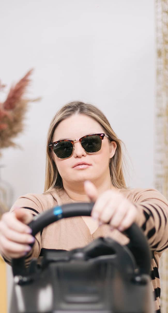 Caterina Moretti conduce un volante de videojuegos con las gafas de sol puestas