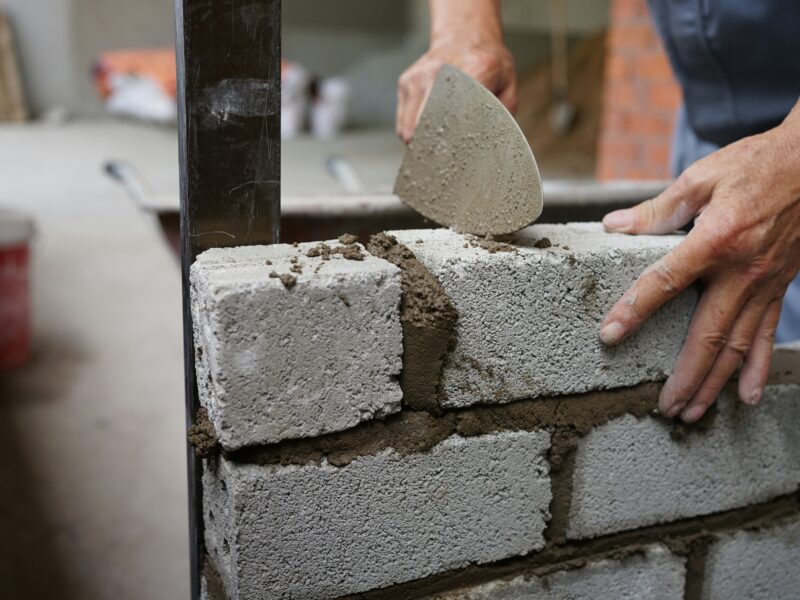 Una persona construye un muro de ladrillo