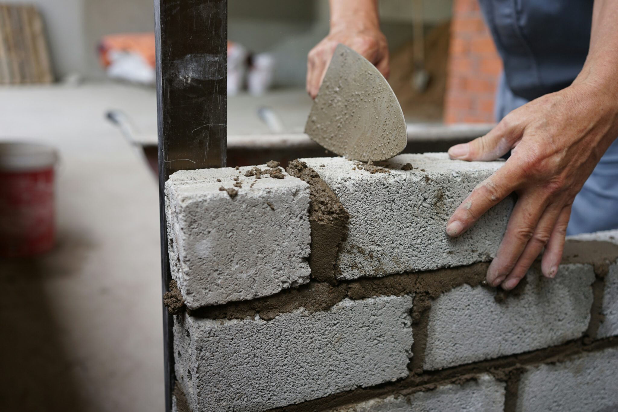 Una persona construye un muro de ladrillo